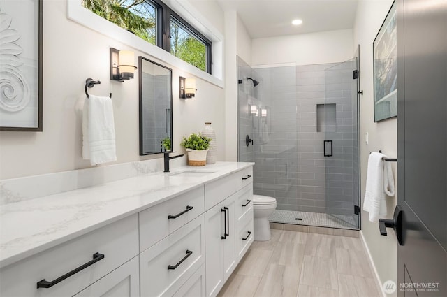 bathroom with vanity, recessed lighting, a stall shower, and toilet