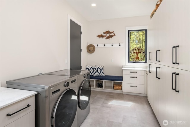 clothes washing area featuring washing machine and dryer, recessed lighting, and cabinet space