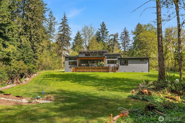 back of property featuring a lawn, a wooden deck, and a sunroom