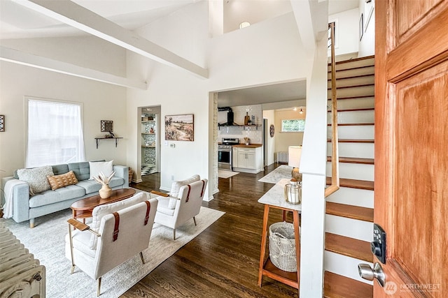 living area featuring stairs, high vaulted ceiling, dark wood-style floors, and a wealth of natural light