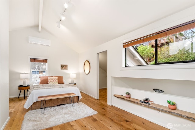 bedroom featuring light wood finished floors, beam ceiling, and multiple windows