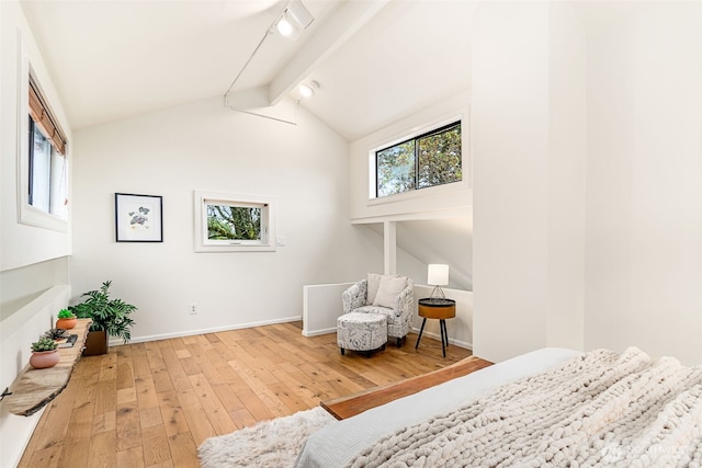 bedroom with baseboards, vaulted ceiling with beams, and hardwood / wood-style floors