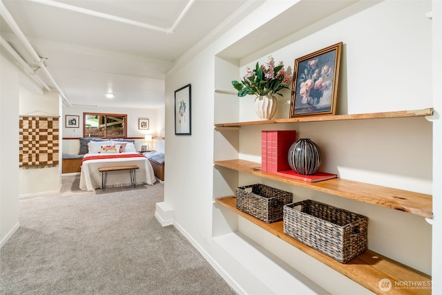 corridor featuring baseboards and carpet flooring