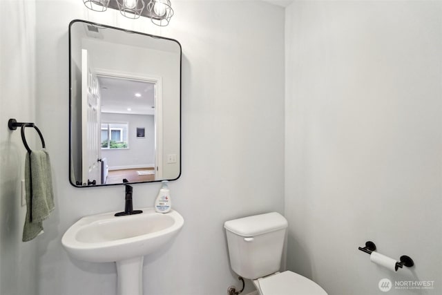 half bathroom featuring a sink and toilet