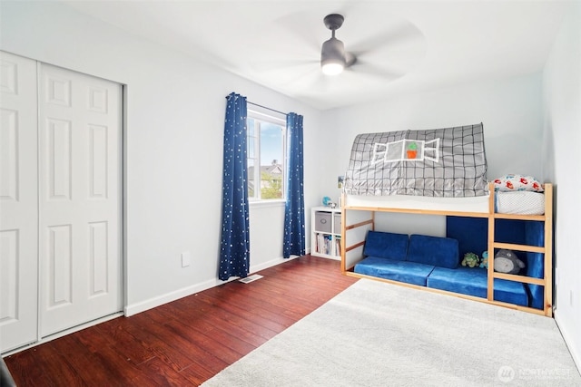 bedroom with ceiling fan, baseboards, visible vents, and wood finished floors