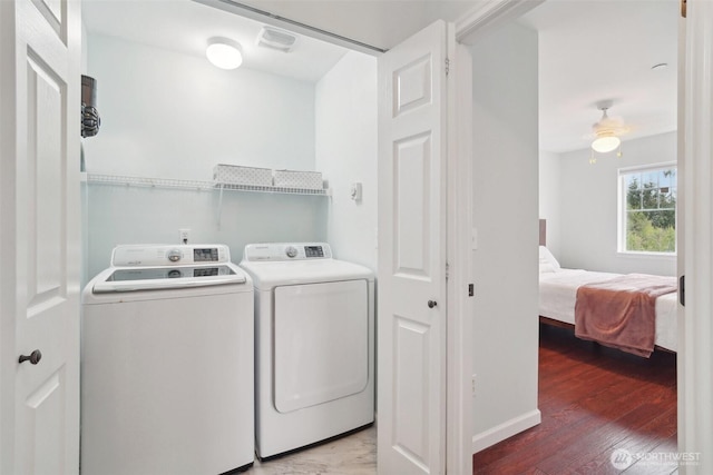clothes washing area featuring laundry area, visible vents, washing machine and dryer, light wood-type flooring, and baseboards