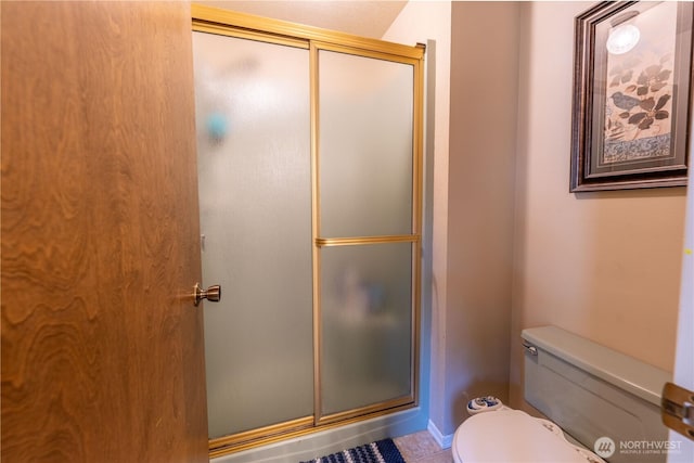full bathroom with toilet, tile patterned floors, and a shower stall