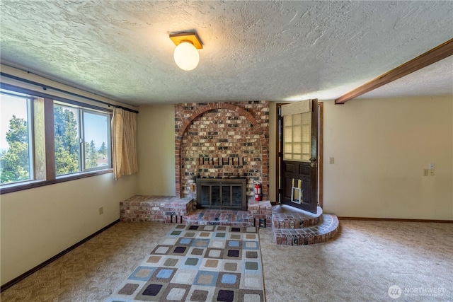 unfurnished living room with a brick fireplace, a textured ceiling, baseboards, and carpet flooring