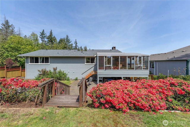back of property featuring a sunroom, fence, and a deck