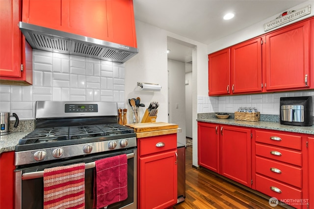 kitchen featuring wall chimney range hood, red cabinets, tasteful backsplash, dark wood finished floors, and gas stove