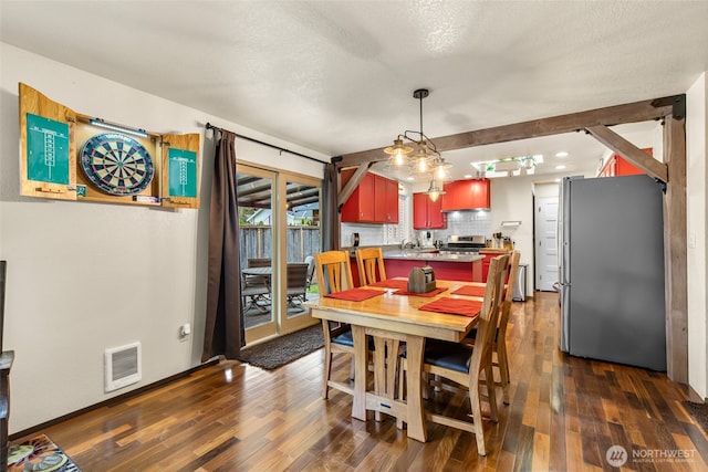 dining area with a textured ceiling, baseboards, dark wood finished floors, and visible vents