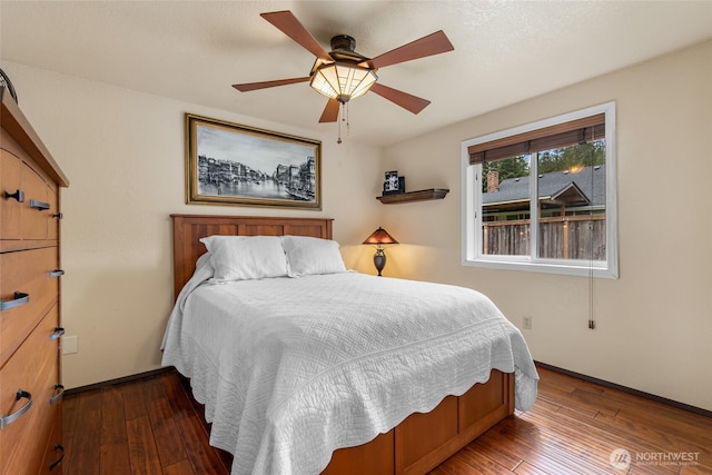 bedroom featuring baseboards, wood-type flooring, and a ceiling fan