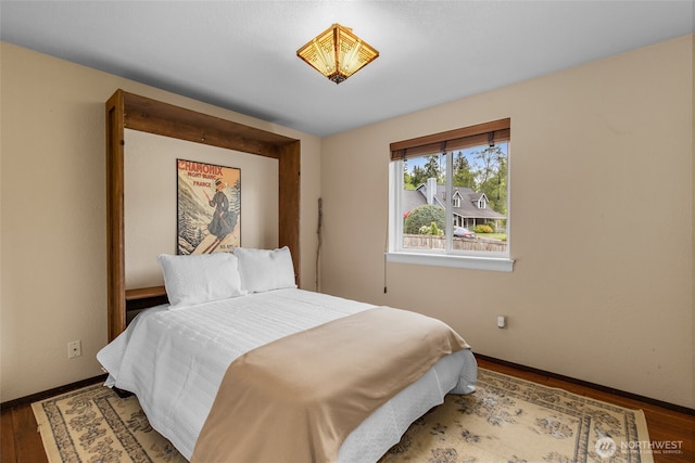 bedroom with baseboards and wood finished floors