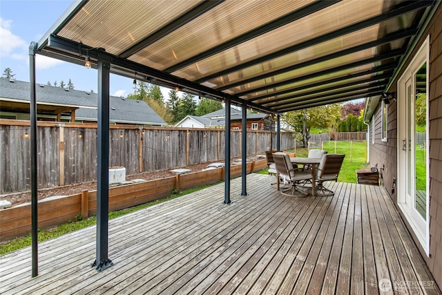wooden deck featuring a fenced backyard, a yard, and outdoor dining space