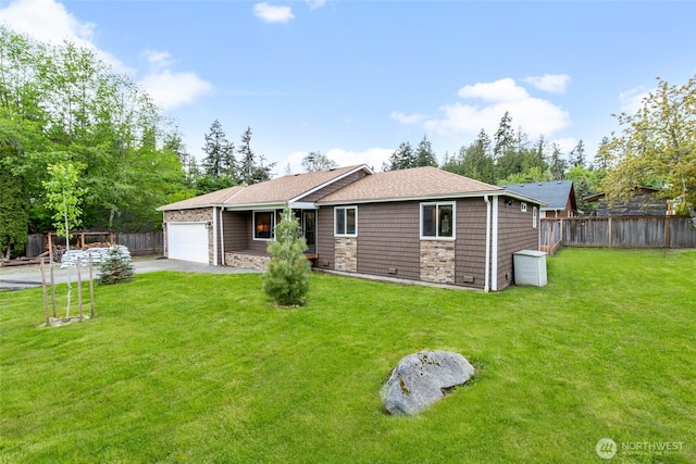back of property with a lawn, fence, and a garage