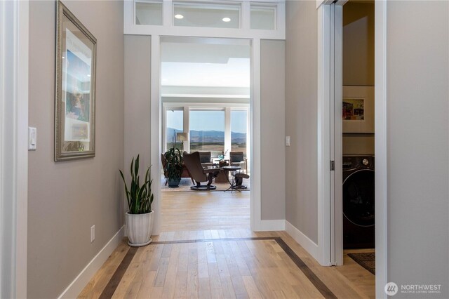 corridor featuring washer / dryer, baseboards, light wood-style floors, and recessed lighting