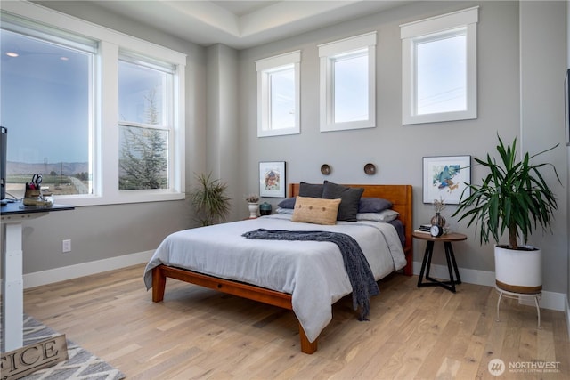 bedroom featuring baseboards and light wood finished floors
