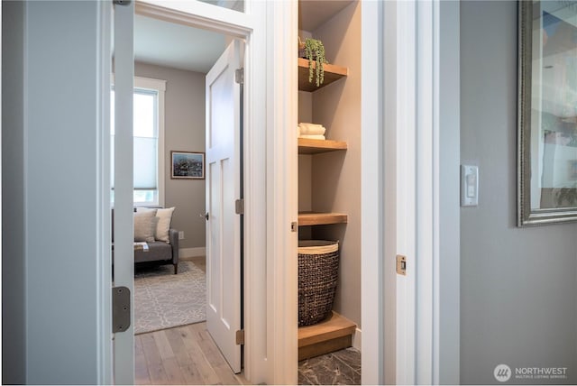 hallway with baseboards and light wood finished floors