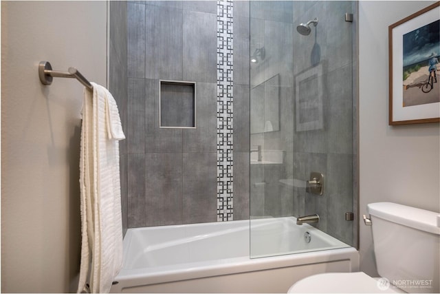 full bathroom with toilet and shower / bath combination with glass door