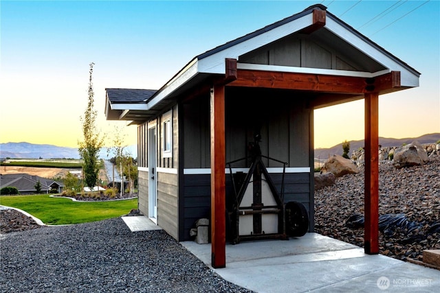 outdoor structure at dusk featuring a mountain view and a yard