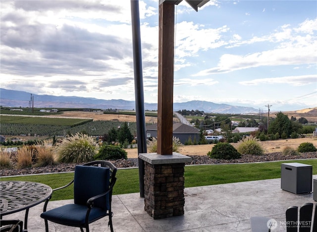 view of patio with a rural view and a mountain view