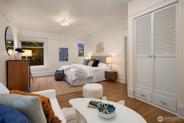 bedroom featuring wood finished floors, a closet, and baseboards