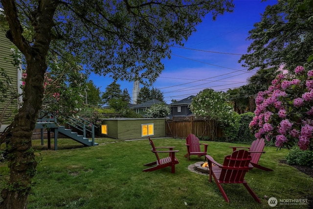 view of yard featuring an outdoor fire pit, an outbuilding, and stairway