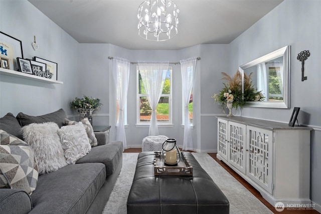 living room featuring baseboards, wood finished floors, and a notable chandelier