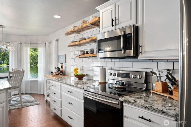 kitchen featuring backsplash, open shelves, appliances with stainless steel finishes, and light stone counters