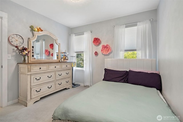 bedroom featuring baseboards and light carpet