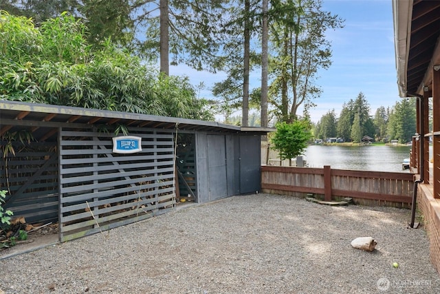 exterior space featuring a water view and fence