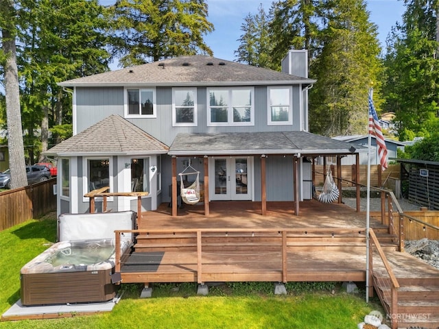 rear view of house with french doors, a hot tub, fence private yard, and a deck