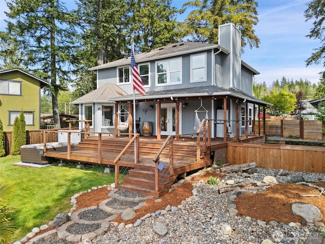 farmhouse inspired home with a front lawn, fence, french doors, a chimney, and a shingled roof