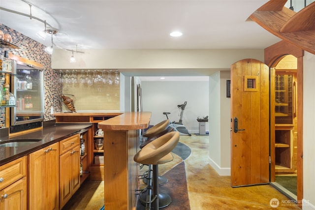 16653 SE 69th Way, Bellevue, WA 98006 - indoor dry bar with finished concrete flooring, baseboards, recessed lighting, and backsplash