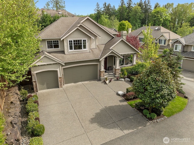 16653 SE 69th Way, Bellevue, WA 98006 - craftsman inspired home featuring concrete driveway, a garage, stone siding, covered porch, and roof with shingles