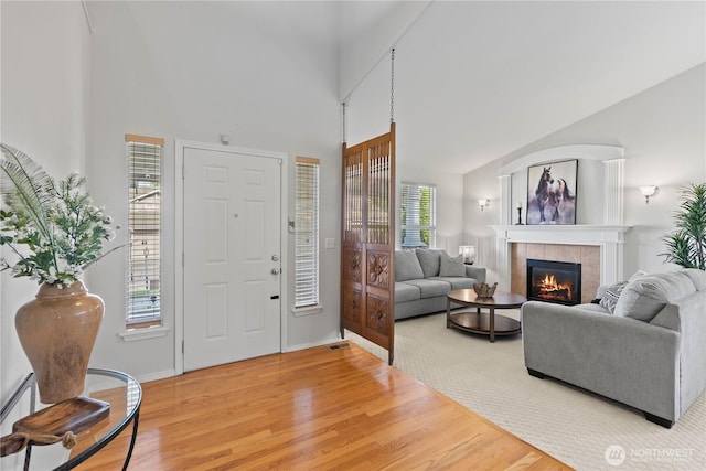 710 122nd Avenue Ct E, Edgewood, WA 98372 - entrance foyer with a towering ceiling, visible vents, light wood-style flooring, and a tile fireplace