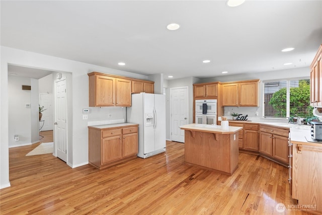 710 122nd Avenue Ct E, Edgewood, WA 98372 - kitchen with light wood finished floors, white appliances, light countertops, a center island, and recessed lighting