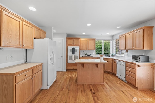 710 122nd Avenue Ct E, Edgewood, WA 98372 - kitchen with a center island, light countertops, a toaster, light wood finished floors, and white appliances