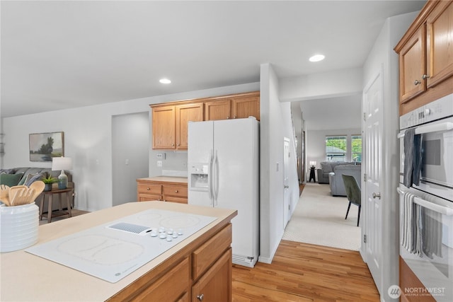 710 122nd Avenue Ct E, Edgewood, WA 98372 - kitchen featuring light countertops, light wood finished floors, white appliances, and open floor plan