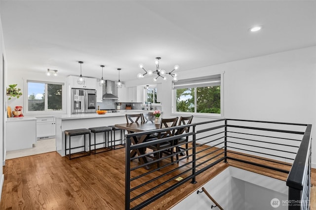 dining area featuring recessed lighting, a notable chandelier, and wood finished floors