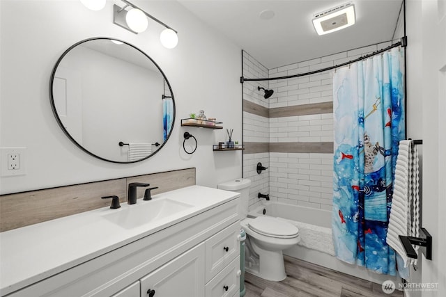 bathroom featuring toilet, wood finished floors, shower / tub combo, and vanity