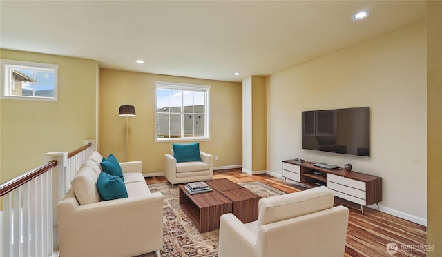 living area featuring recessed lighting, baseboards, and wood finished floors