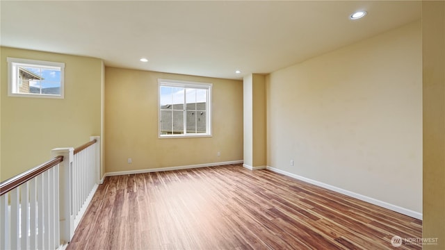 spare room with recessed lighting, baseboards, and wood finished floors