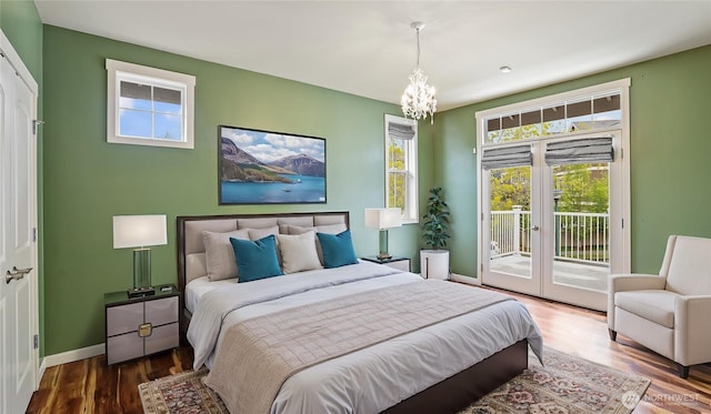 bedroom featuring french doors, wood finished floors, baseboards, a chandelier, and access to outside