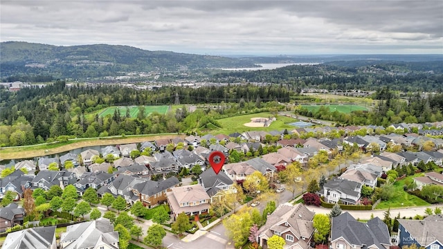 drone / aerial view featuring a mountain view, a residential view, and a forest view