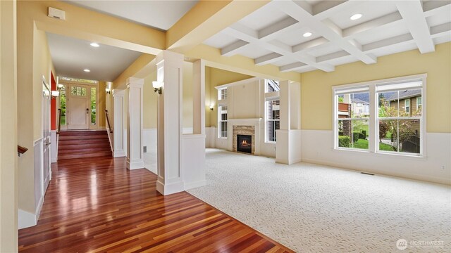 unfurnished living room featuring wood finished floors, beamed ceiling, ornate columns, coffered ceiling, and recessed lighting