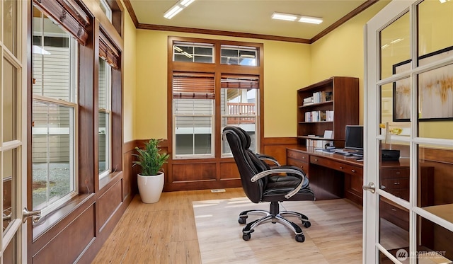 office with crown molding, light wood finished floors, and a wainscoted wall