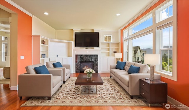 living room with baseboards, recessed lighting, wood finished floors, and a fireplace