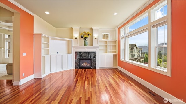 unfurnished living room featuring recessed lighting, baseboards, wood finished floors, and a fireplace