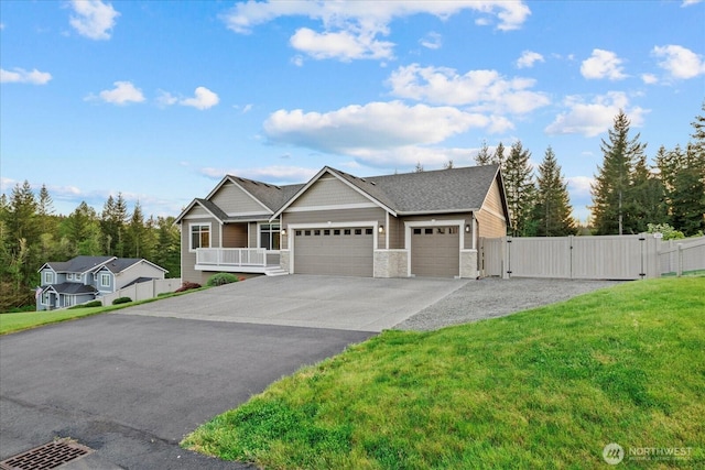 ranch-style home with a front yard, stone siding, a gate, concrete driveway, and an attached garage